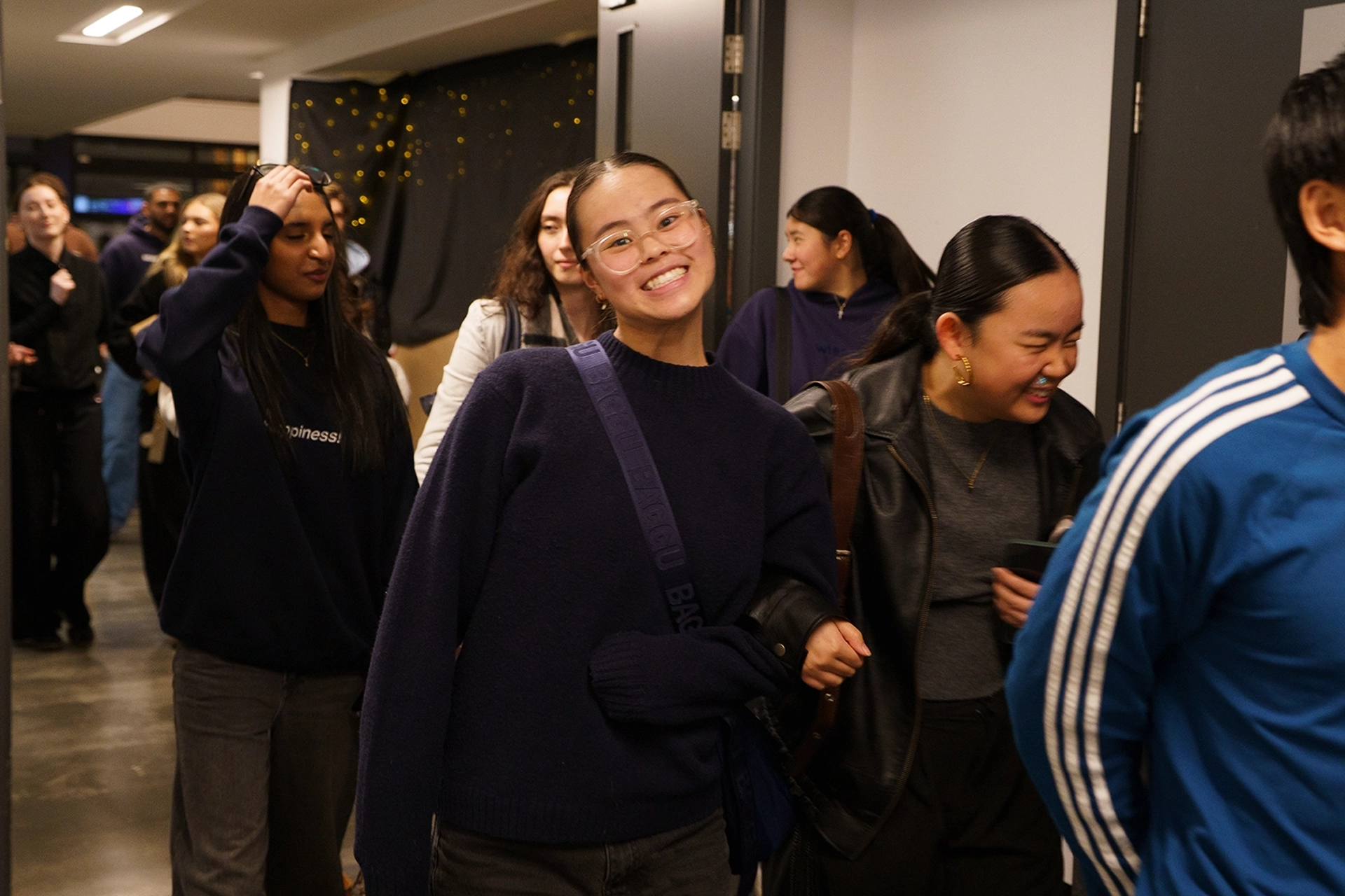 Young adults smiling and waving as they arrive at church